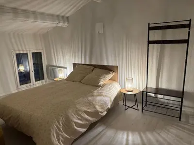 a bedroom with a large bed and two tables at Carpentras cosy& 3 voyageurs& in Carpentras
