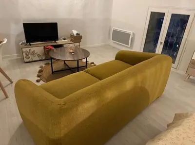 a living room with a green couch and a table at Carpentras cosy& 3 voyageurs& in Carpentras