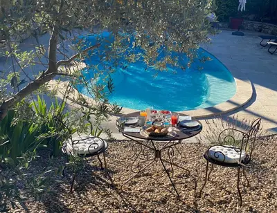 a table with food on it next to a swimming pool at la chamade grande chambre B&B indépendante in Ventabren