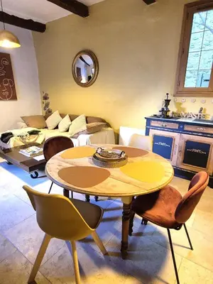 a living room with a table and a couch at Au Lys rose in LʼIsle-sur-la-Sorgue