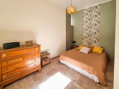 a small bedroom with a bed and a dresser at Au Lys rose in LʼIsle-sur-la-Sorgue