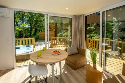 a living room with a table and a patio at Camping Le Luberon in Apt