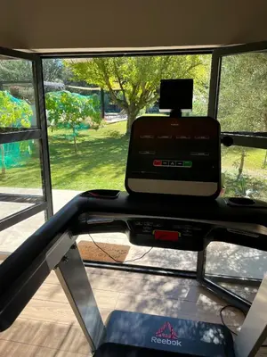 a treadmill in a gym with a large window at Domaine d'Hestia le gite Victoria in Rognes
