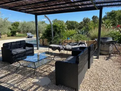a patio with two couches and a glass table at Gîte des Pape in Bédoin
