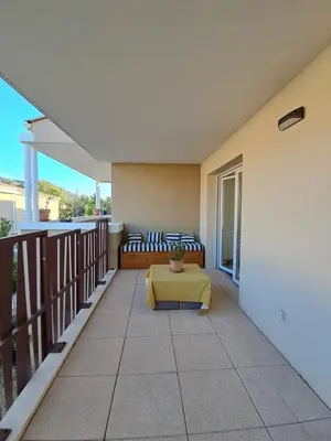 a patio with a couch and a table on a balcony at Appartement cosy centre Robion in Robion en Luberon
