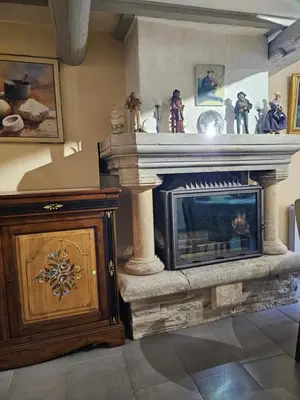 a living room with a fireplace and a wooden cabinet at la petite maison in Céreste