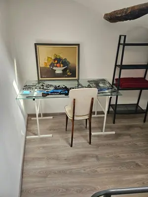 a glass table with a chair and a painting on the wall at la petite maison in Céreste