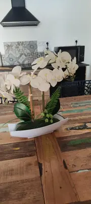 a plate with white flowers on a wooden table at maison_du_sud_13140 in Miramas