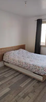 a bed in a bedroom with a wooden floor at maison_du_sud_13140 in Miramas