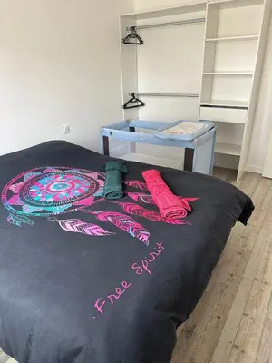 a bed with a black comforter with red pillows on it at maison_du_sud_13140 in Miramas