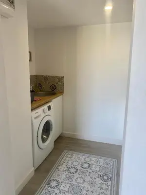 a laundry room with a washing machine and a sink at Au pied du luberon in Pertuis
