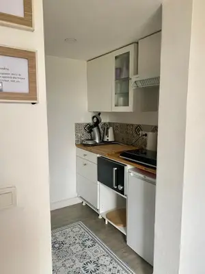 a kitchen with white cabinets and a stove top oven at Au pied du luberon in Pertuis