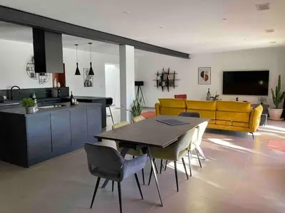a living room with a table and a yellow couch at Gîte Thaliana in Saumane-de-Vaucluse