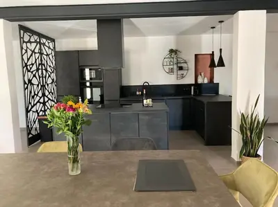 a kitchen with a table with a vase of flowers on it at Gîte Thaliana in Saumane-de-Vaucluse