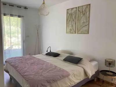 a bedroom with a large bed in a white room at Gîte Thaliana in Saumane-de-Vaucluse