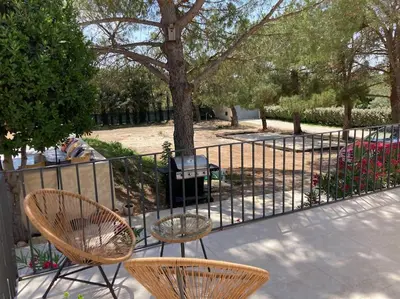 two chairs and a table next to a fence at Gîte Thaliana in Saumane-de-Vaucluse