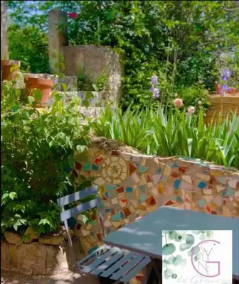 a bench sitting in a garden next to a garden at La glycine in Saint-Marc-Jaumegarde