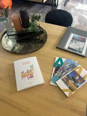 a table with pamphlets and magazines on a table at La glycine in Saint-Marc-Jaumegarde