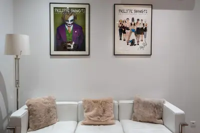 two framed movie posters on a white wall with a couch at Le Yona Mirabeau - Appartement T3 Atypique situé dans le centre ville historique - proche Rotonde in Aix-en-Provence