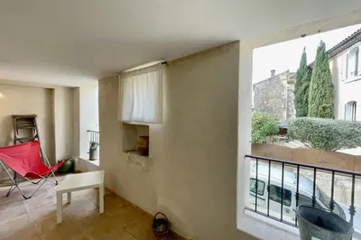 a living room with a large window and a red chair at Village house Stella in Saint-Cannat