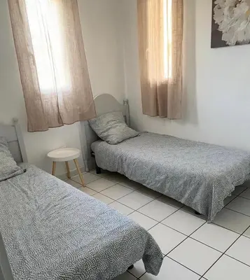 a bedroom with two beds and a large window at Villa Tia - Appartement 2 chambres - piscine - bord de lac in Saint-Saturnin-lès-Avignon