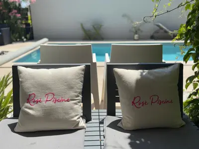 two pillows sitting on chairs in front of a pool at La Cassiopée in Caromb