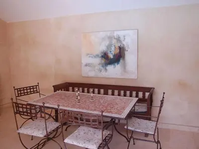 a table and chairs with a painting on the wall at Camargue Modern retreat in Cavaillon