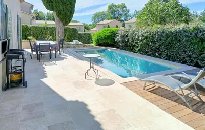 a swimming pool with a table and chairs next to a house at Awesome Home In Saint-Rémy-De-Provence in Saint-Rémy-de-Provence