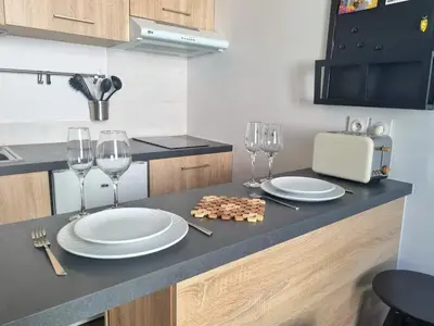 a kitchen with two plates and wine glasses on a counter at Joli studio en plein centre historique in Aix-en-Provence