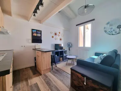 a living room with a blue couch and a table at Joli studio en plein centre historique in Aix-en-Provence