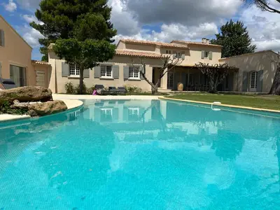 a large blue swimming pool in front of a house at LAVENINE a Modène in Modène