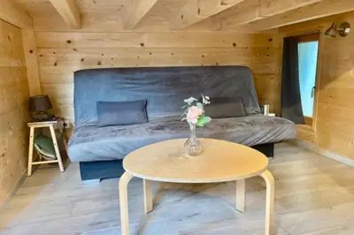 a living room with a couch and a table at Charming Tiny House in LʼIsle-sur-la-Sorgue