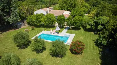 an aerial view of a backyard with a swimming pool at La Villa aux Cyprès bleu in Le Thor