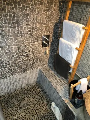 a bathroom with a shower with a tiled wall at AIX Centre LOFT Duplex Terrasse climatisation wifi in Aix-en-Provence