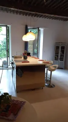 a kitchen with a island in the middle of a room at Clos des Jasmins avec sa jolie cour intérieure in Lourmarin