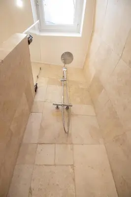 a bathroom with a shower with a chair on the floor at Le Triplex - 8 pers - Hypercentre - Wifi in LʼIsle-sur-la-Sorgue