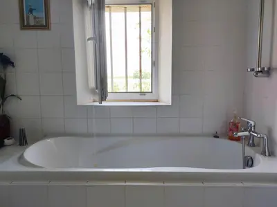 a bath tub in a bathroom with a window at Chambre 3 personnes avec salle de bain dans mas du Lubéron in Robion en Luberon