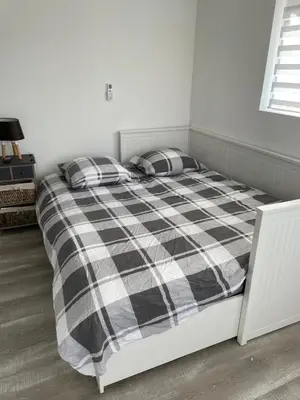 a bedroom with a bed with a black and white plaid blanket at La maison Anaïa in Gargas