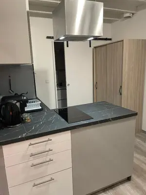 a kitchen with white cabinets and a black counter top at La maison Anaïa in Gargas