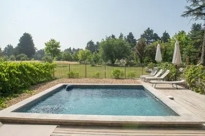a pool in a yard with a deck and chairs at Proche l'Isle/Sorgue, loft avec SPA et Piscine in Le Thor