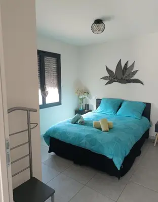 a bedroom with a blue bed with blue sheets at La Cigale sous l'Olivier - Chambre , SdB et Salon Privé - Piscine in Les Taillades