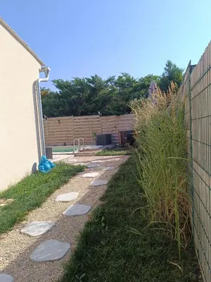 a garden path with stepping stones next to a fence at La Cigale sous l'Olivier - Chambre , SdB et Salon Privé - Piscine in Les Taillades