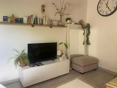 a living room with a tv on a white cabinet at A 20 minutes de Aix en Provence in Pertuis