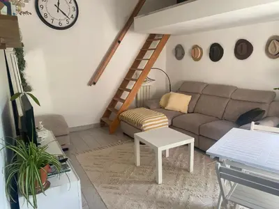 a living room with a couch and a clock on the wall at A 20 minutes de Aix en Provence in Pertuis