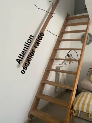 a wooden spiral staircase with a sign on the wall at A 20 minutes de Aix en Provence in Pertuis