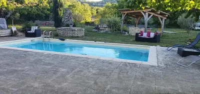 a swimming pool with chairs and a gazebo at CHRIS LE VERGER in Saignon