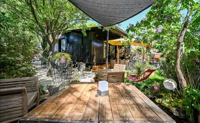 a patio with a wooden table and benches at Nouveau ENVOUTEMENT près de GORDES Provence Maison entière neuve archi luxe écolo 4 pers parking privé in Robion en Luberon