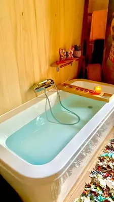 a bath tub with a faucet with blue water at Nouveau ENVOUTEMENT près de GORDES Provence Maison entière neuve archi luxe écolo 4 pers parking privé in Robion en Luberon