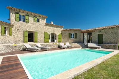 a swimming pool in front of a house at La Bastide Des As in Gordes