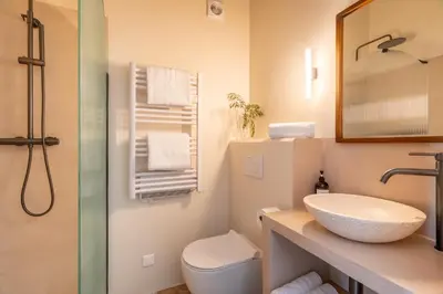 a bathroom with a sink and a toilet and a mirror at La Bastide Des As in Gordes